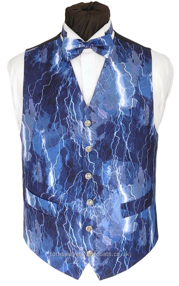 A striking lightning pattern in shades of blue from dusty blue to navy. Available in extra long length as well as extra large sizes. Waistcoat Style- TS564- Front Fabric- Cotton- Colour- White on Shades of Blue- Buttons- Silver Pattern Metal Effect- Back & Lining- Navy Poly Twill- You can click here to view our waistcoat size chart.